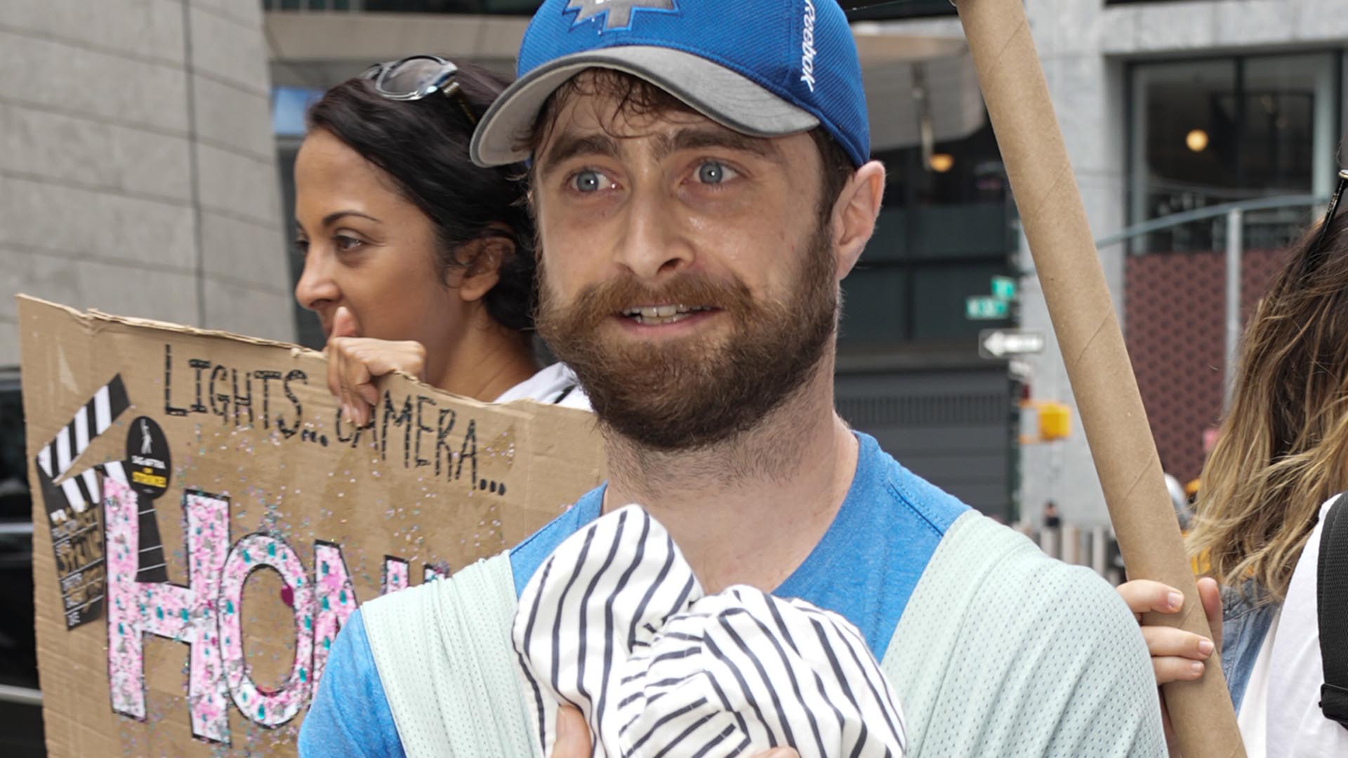Daniel Radcliffe surge com o filho no colo em manifestação