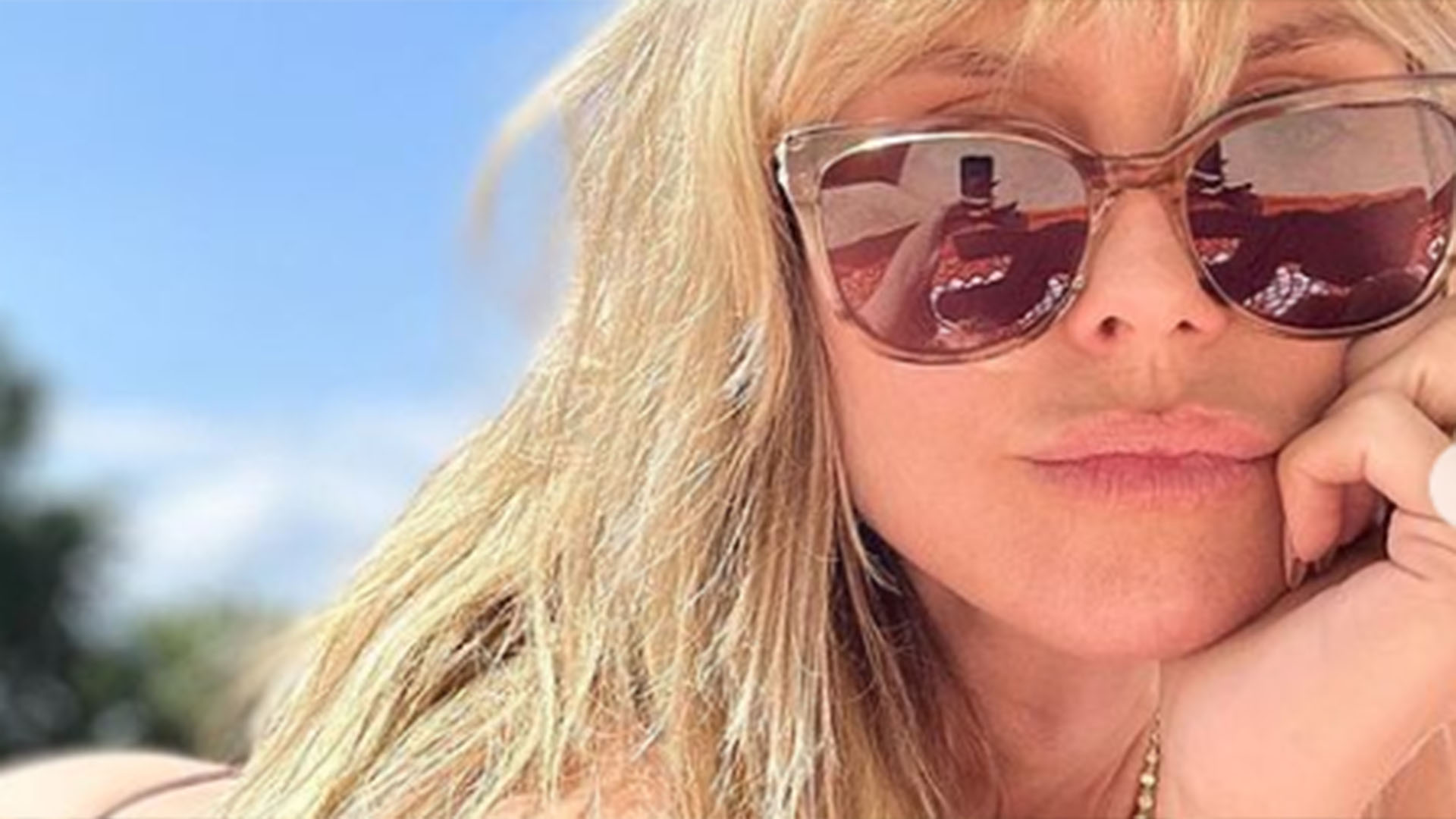 De topless, Heidi Klum renova o bronzeado no jardim
