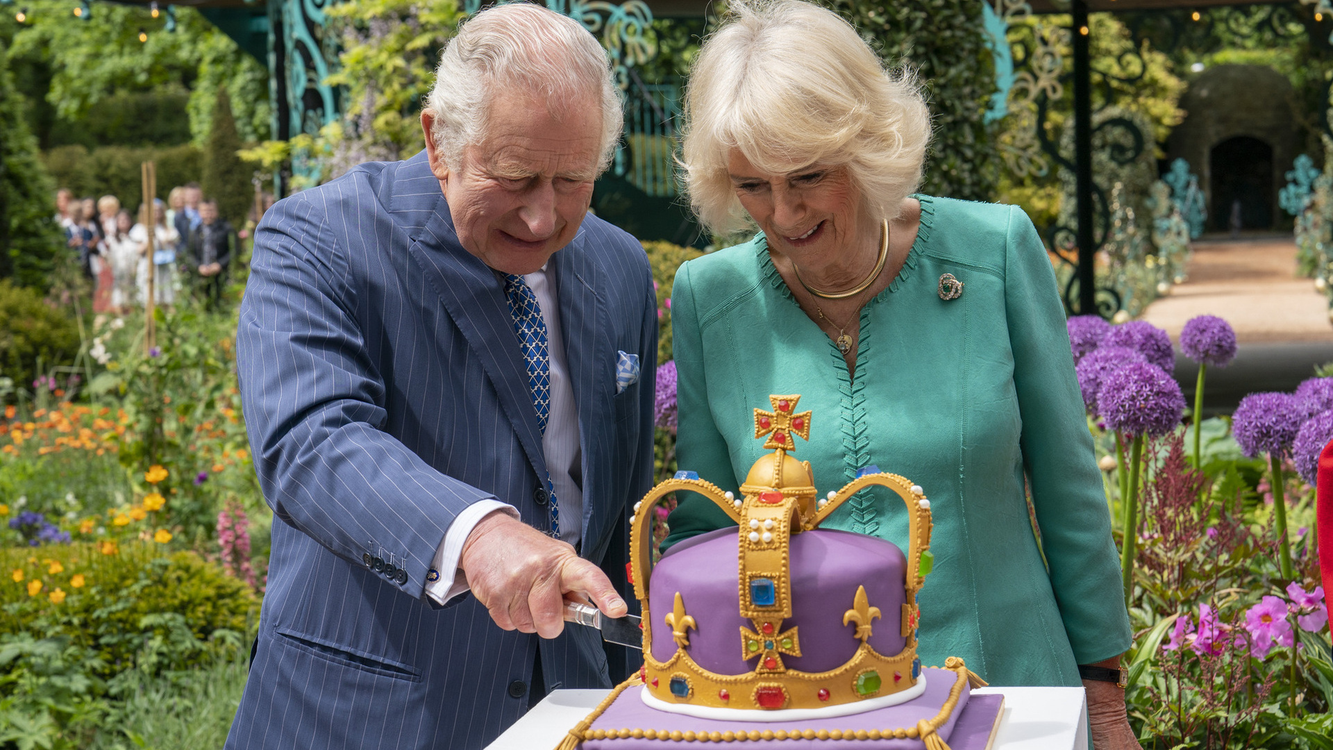 Rei Charles III e Rainha Camilla cortam bolo em formato de coroa em nova visita real