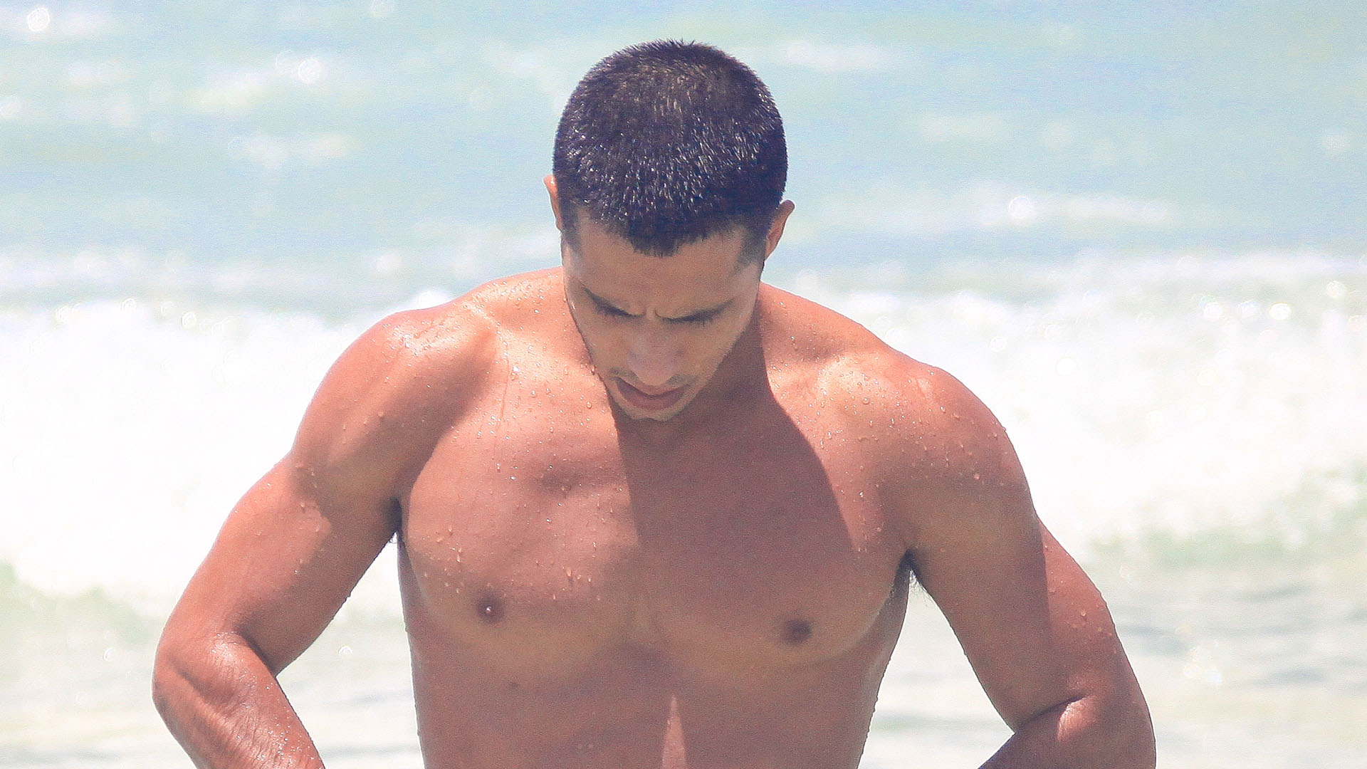 Astro de Terra e Paixão, Rafael Gualandi é flagrado dando ajeitadinha no look na praia