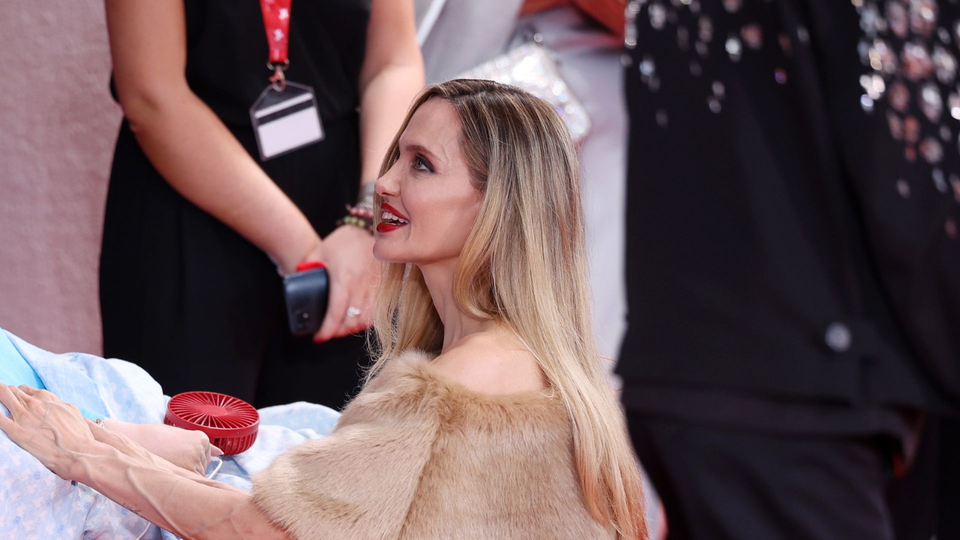 Angelina Jolie se ajoelha para falar com fã em cama hospitalar