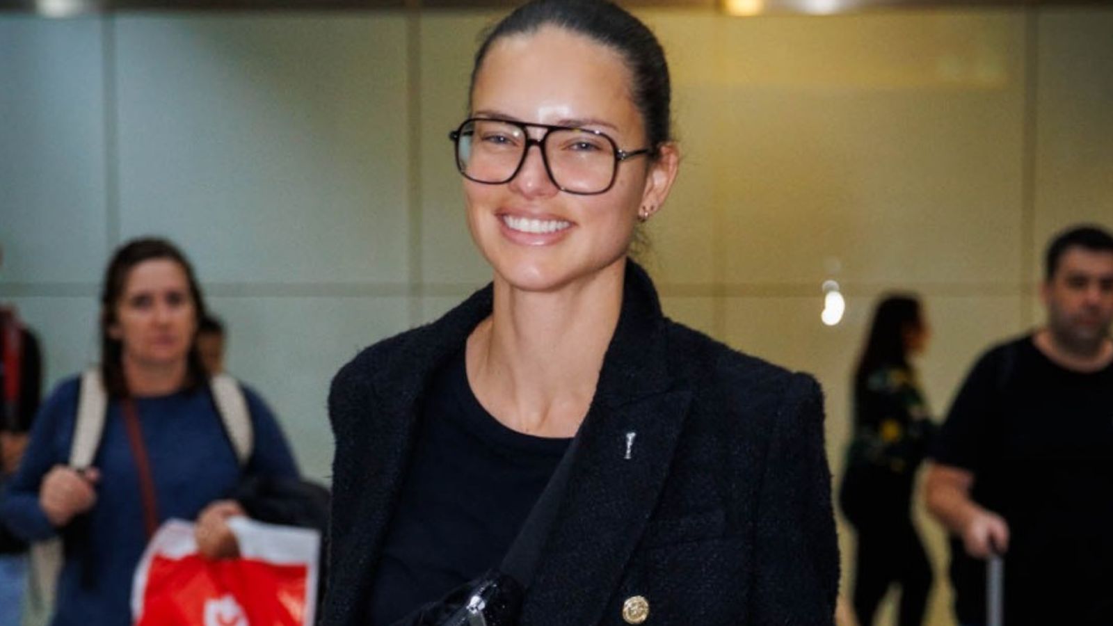 Adriana Lima faz rara aparição sem maquiagem ao desembarcar em SP