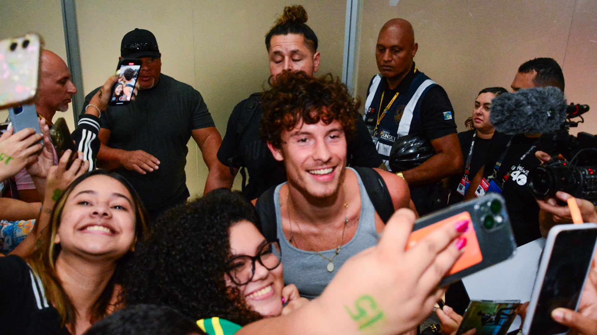 Todo sorridente, Shawn Mendes chega ao Brasil e posa com fãs no aeroporto