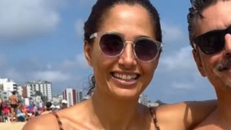 Camila Pitanga posa sorridente ao lado do noivo em dia de praia