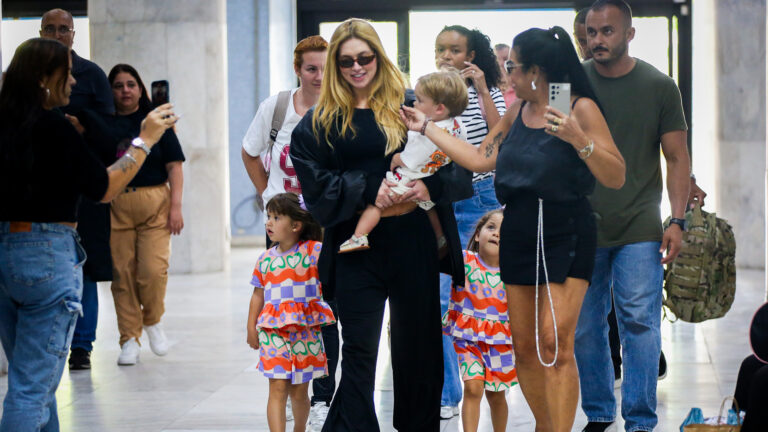 Virginia é flagrada no aeroporto com os filhos na volta para casa