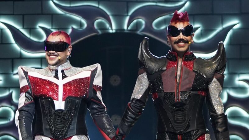 Eduardo Camargo e Filipe Oliveira, do canal Diva Depressão, de mãos dadas no palco da final do Corrida das Blogueiras 7 em São Paulo