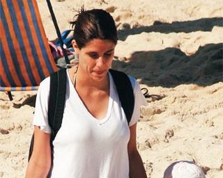 Ao deixar a praia do Arpoador, Rio, com a filha, Rafaela leva o lixo embora.