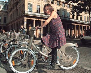 A atriz e cantora aluga uma bicicleta em frente do histórico teatro da Comédie-Française.