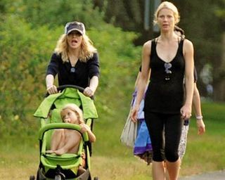 Às vésperas de fazer 50 anos e estrear turnê, Madonna recarrega energias na praia com a atriz e sua filha Apple. David Banda, caçula da diva, senta no banco de trás do carrinho duplo.