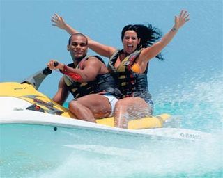 Nas águas cristalinas de Jolly Beach, na ilha de Antígua, Tony e Scheila se divertem no passeio de jet-ski.