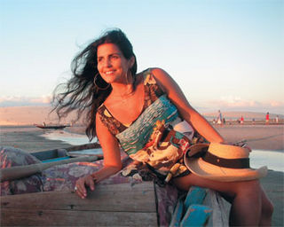 Na praia de Mucuripe, em Fortaleza, Thereza admira o pôr-do-sol debruçada em canoa de pescador.