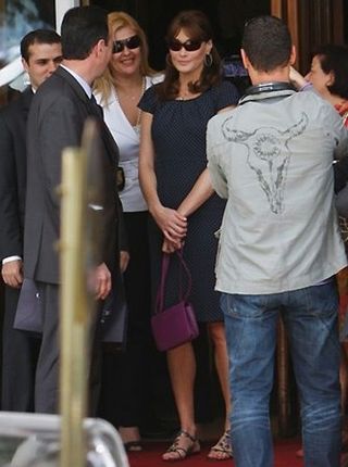 Carla Bruni exibe unhas vermelhas em rasteiras de pedras…