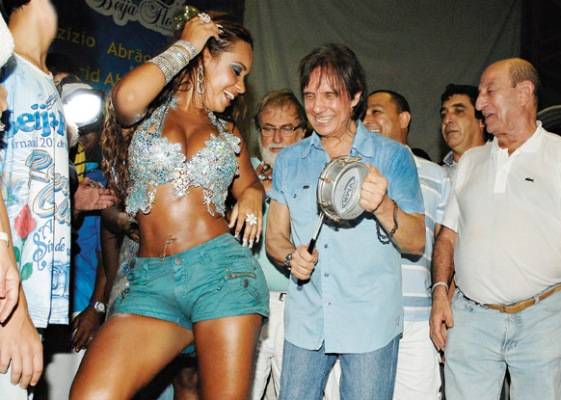 Tema da escola em 2011, o Rei agita a quadra da azul-e-branco, em Nilópolis. Ao lado do presidente Aniz Abraão David, toca tamborim para a rainha de bateria, Raíssa Oliveira.