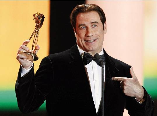 Astro John Travolta festeja láurea com Robin Gibb, Eros Ramazzotti e Anna Loos