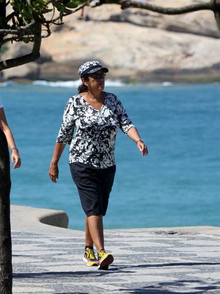 Regina Casé caminha na orla de Ipanema