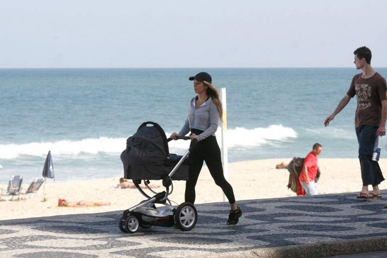 Danielle Winits passeia com bebê na praia