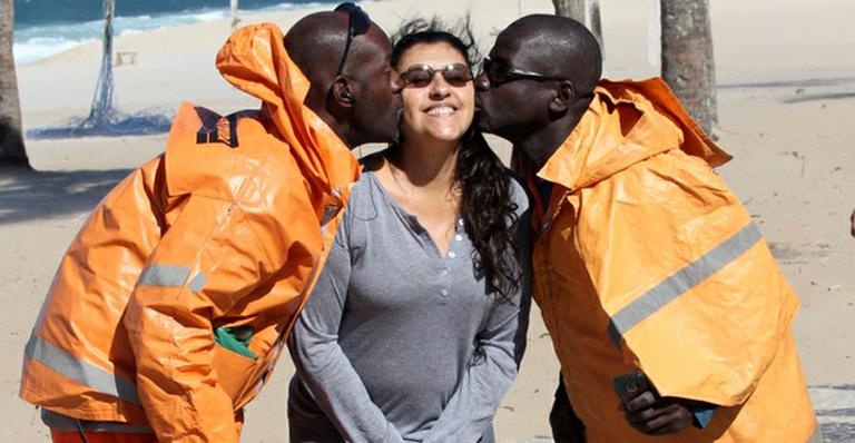 Regina Casé ganha beijo de garis na praia