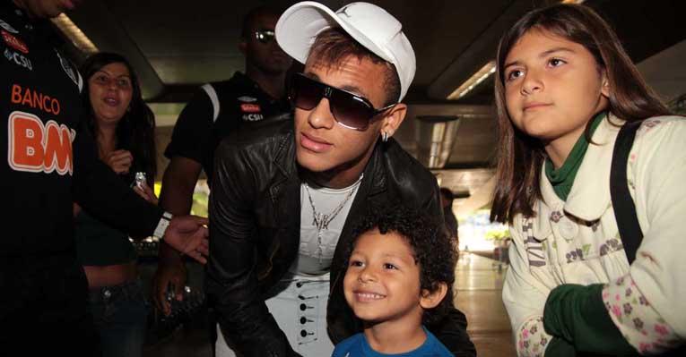Neymar fotografa com fãs em aeroporto