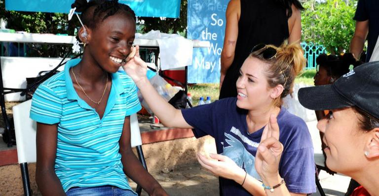 Miley Cyrus visita o Haiti e conversa com crianças