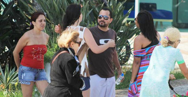 Luciano Camargo passa tarde na praia com a mulher e atende fãs