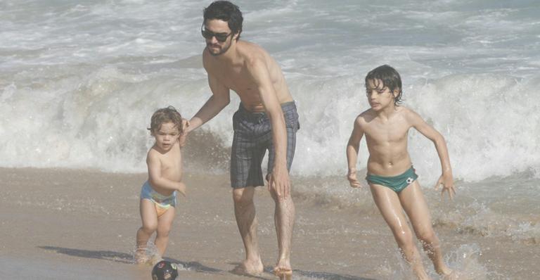 Caio Blat passa dia na praia com o filho e o enteado