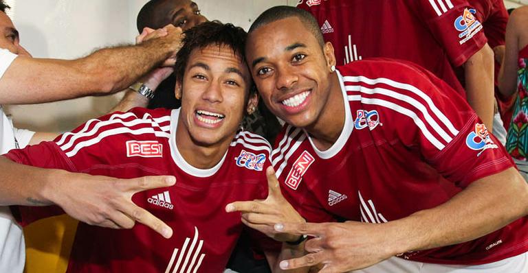 Sob chuva, Neymar e Robinho jogam futebol pelo bem