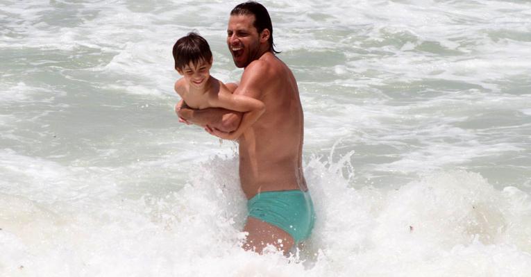 Henri Castelli brinca com o filho, Lucas, na praia