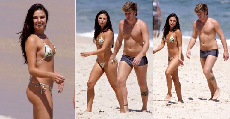 Com o corpo em forma, Ísis Valverde desfila na praia com o namorado