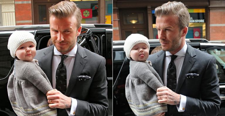 Fofa: No colo do papai David Beckham, Harper mostra a língua em NY