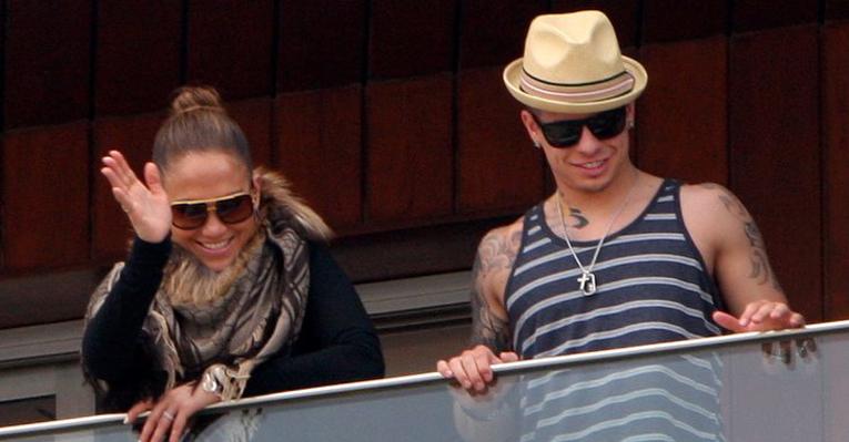 Ao lado do namorado, Jennifer Lopez acena para os fãs da sacada do hotel no Rio