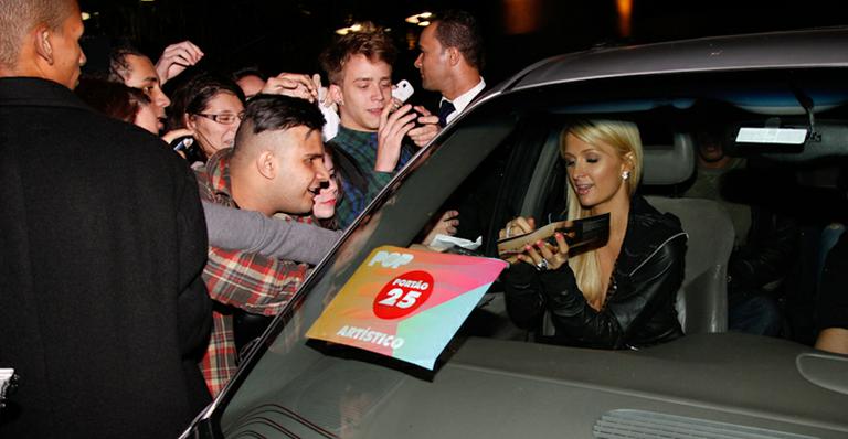 Paris Hilton distribui autógrafos ao deixar hotel em São Paulo