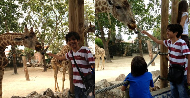 Matheus Costa visita zoológico em Lisboa e alimenta uma girafa