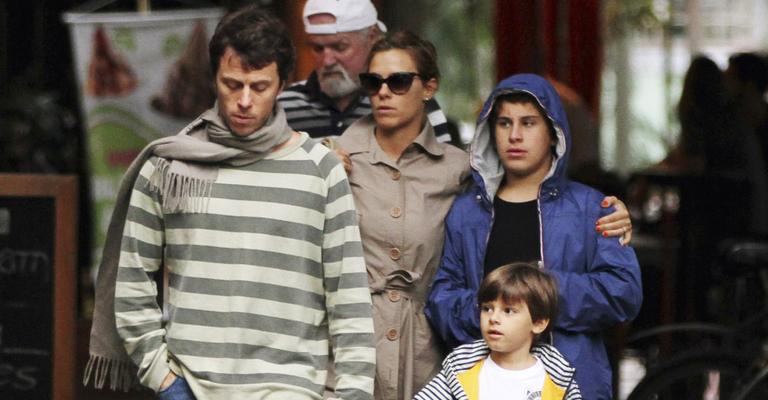 Carolina Dieckmann faz passeio familiar em dia chuvoso
