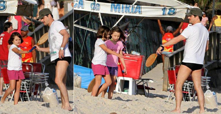Marcelo Serrado joga frescobol com a filha, Catarina, em praia do Rio de Janeiro