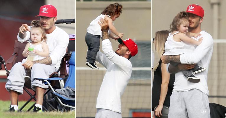 Harper assiste a jogo de futebol dos irmãos no colo do pai, David Beckham