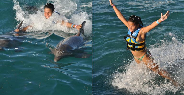 Laura Barreto ‘pega carona’ com golfinho em Cancun