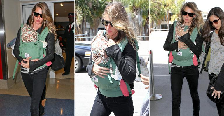 Gisele Bündchen carrega a filha em bolsa-canguru em aeroporto