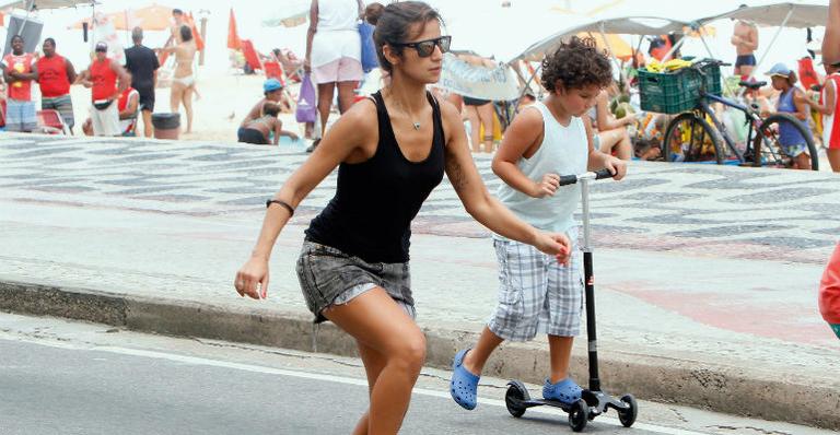 Paula Morais passeou pela orla do Leblon, no Rio, com o enteado Alex