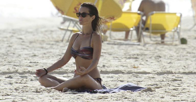 De biquíni, Juliana Didone medita em praia no Rio de Janeiro