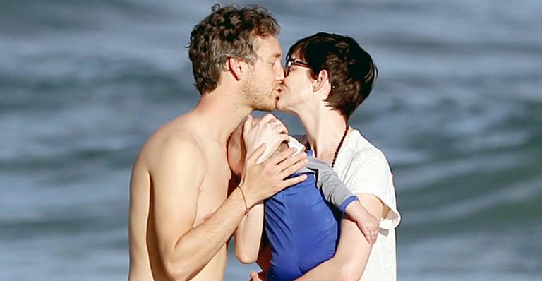 Após afogamento, Anne Hathaway se diverte com o marido e bebê na praia