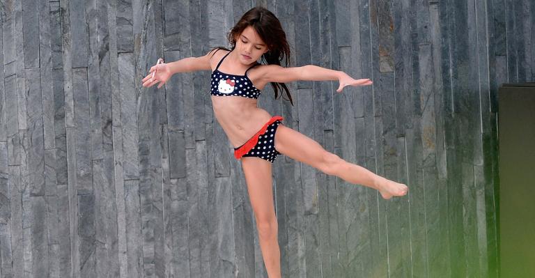 Suri Cruise exibe sua elasticidade ao fazer movimento de balé de biquíni
