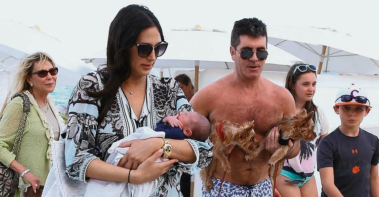 Ao lado da mulher, Simon Cowell leva seu primeiro filho a praia