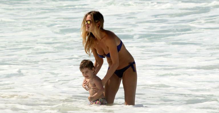 Letícia Birkheuer faz brincadeiras com o filho, João Guilherme, em praia do RJ