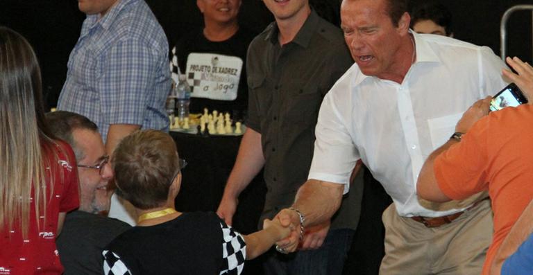 Arnold Schwarzenegger brinca com fã mirim em evento esportivo no Brasil