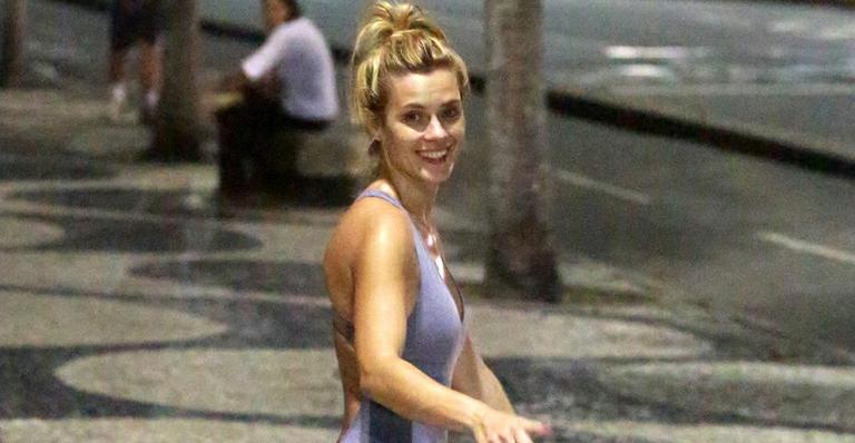 Com macacão justinho, Carolina Dieckmann faz exercícios na orla carioca