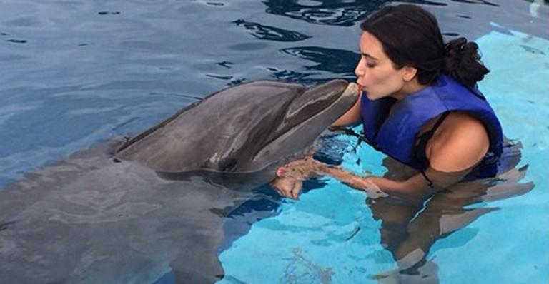 Kim Kardashian mergulha com golfinhos em férias