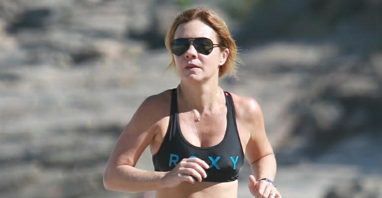 Com a barriga à mostra, Adriana Esteves corre na orla carioca