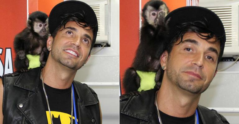 Latino ensina o seu macaco a andar de triciclo
