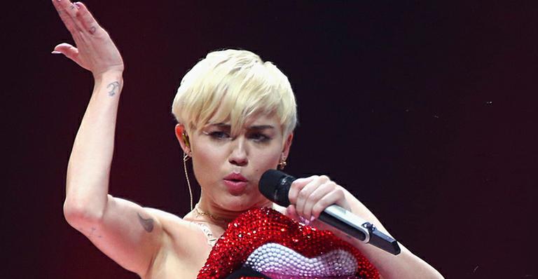 Miley Cyrus posa sem roupa ao lado dos cachorros na cama