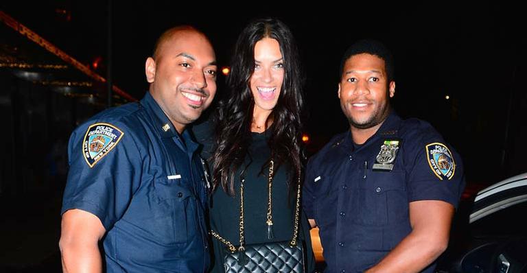 Após desfile, Adriana Lima posa para várias fotos com policiais em Nova York